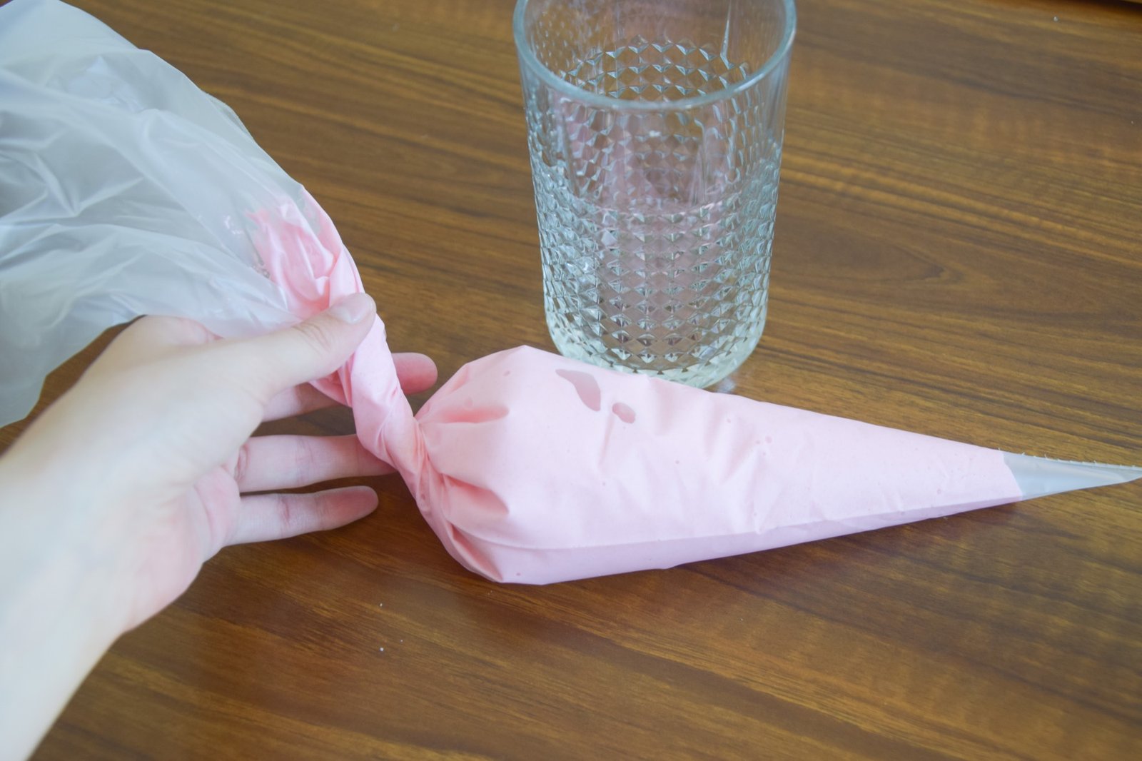 Transferring pink macaron batter into a piping bag