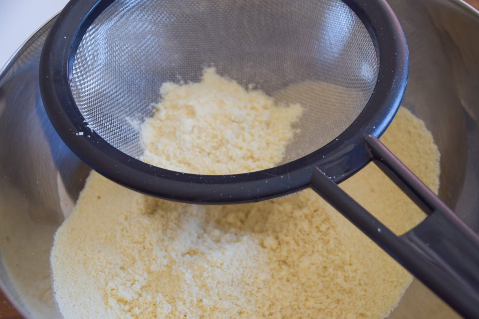 Sifting almond flour and powdered sugar for macarons