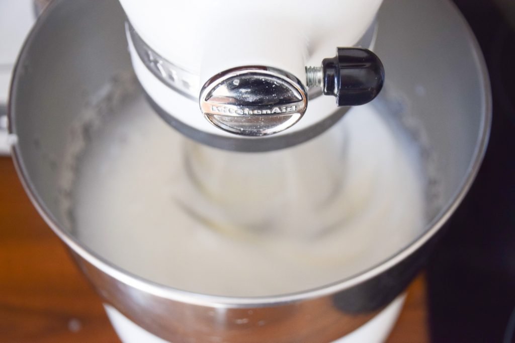 Mixing the egg whites with a hot sugar syrup