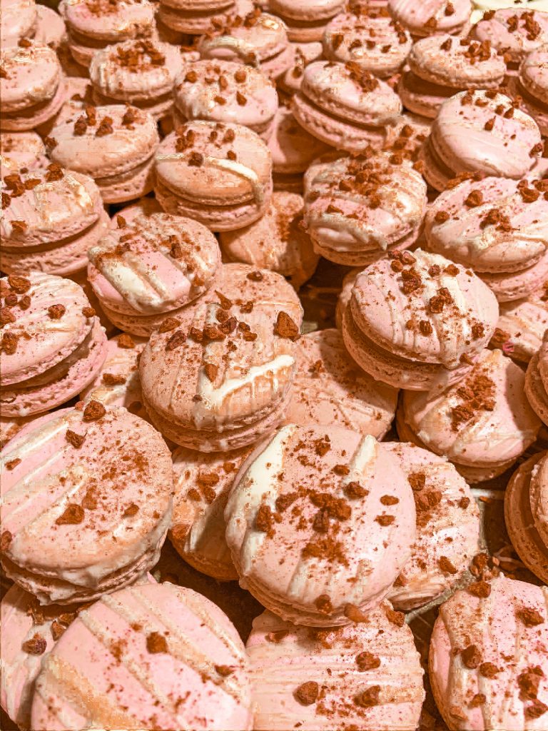Brown chocolate macarons with crushed cookies on it