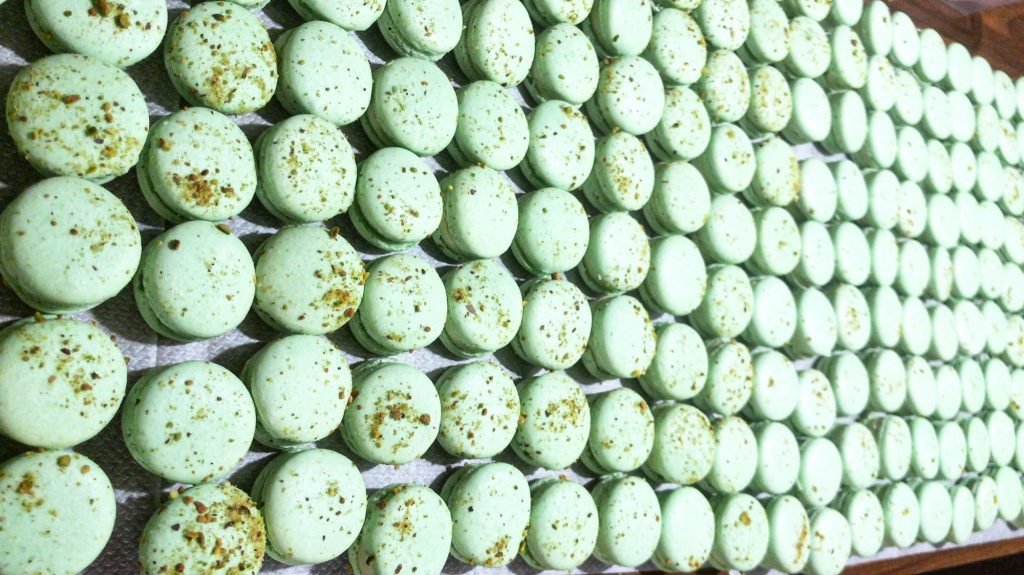 Pistachio macarons with finely ground nut topping
