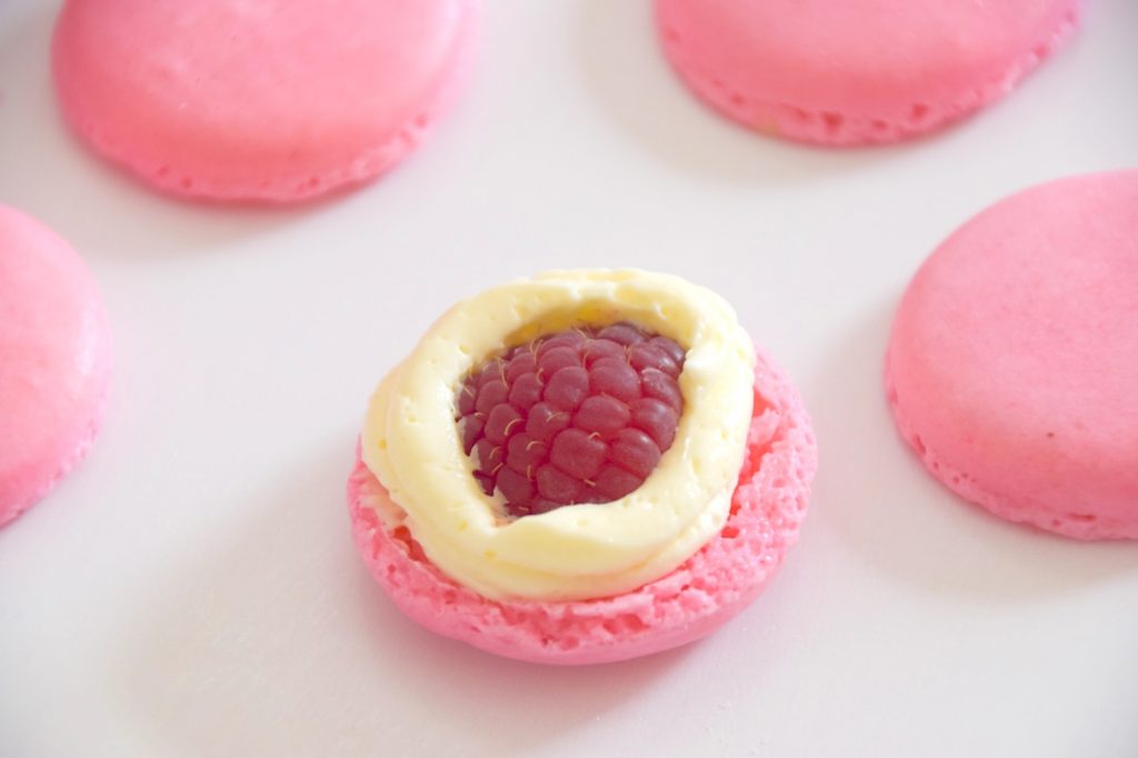 Pink macarons with fresh raspberries