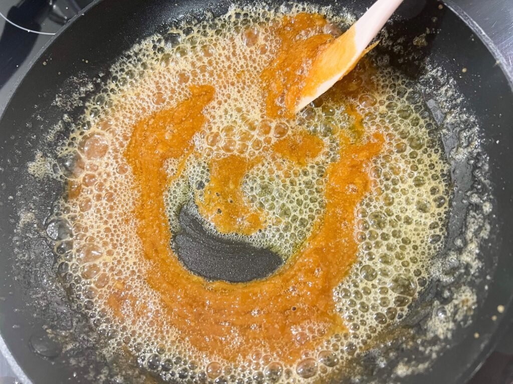 Homemade salted caramel sauce cooking on a pan with butter