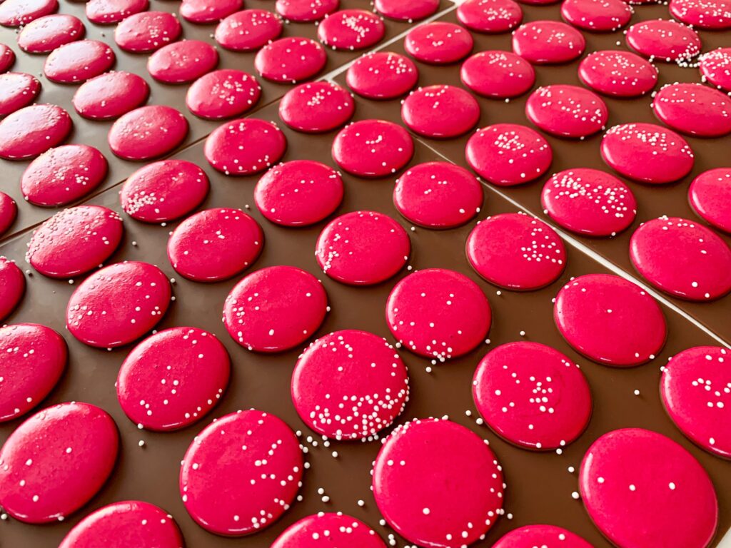 Pink macarons on silicone baking mat