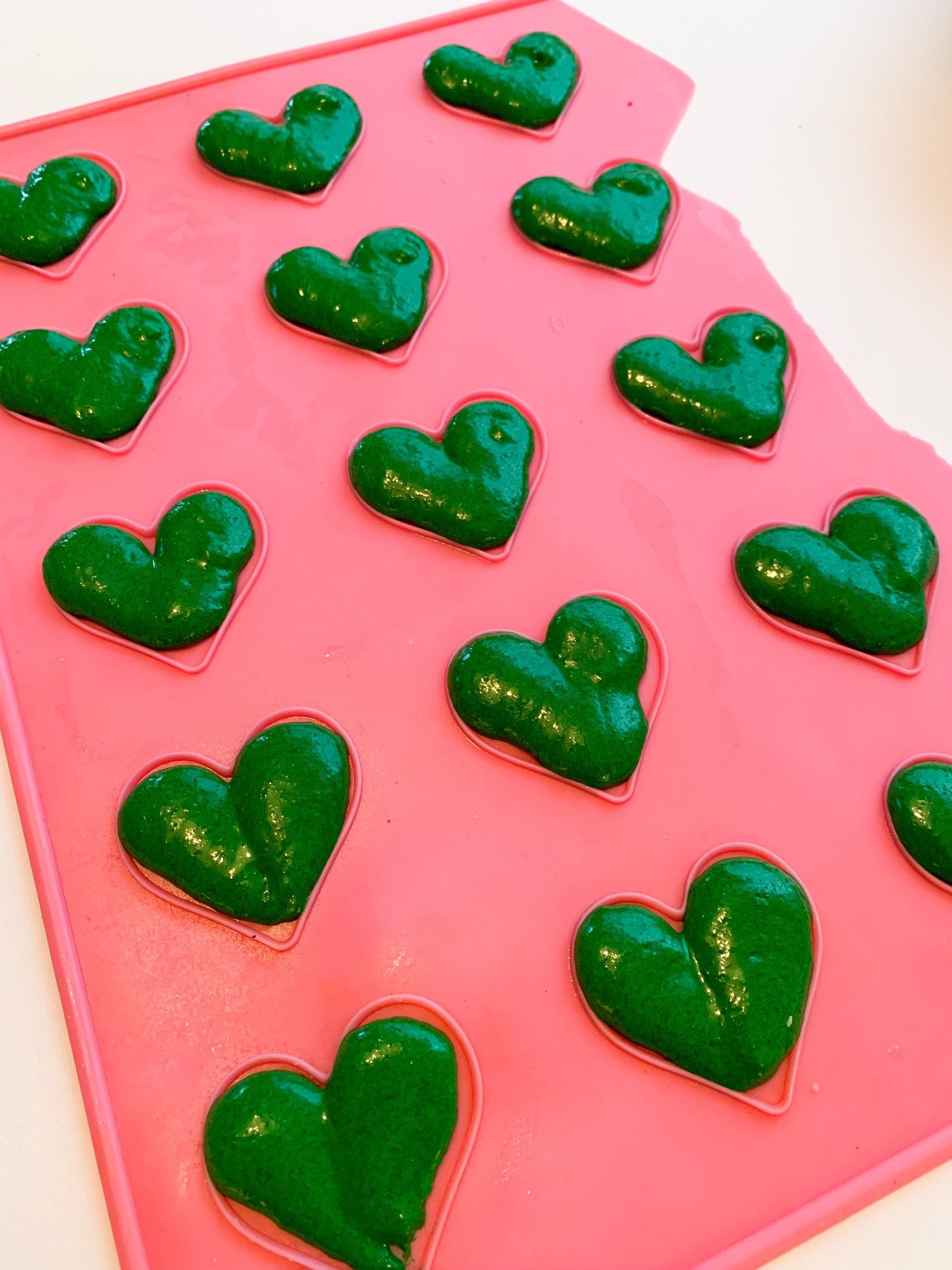 Piping green batter over a heart template