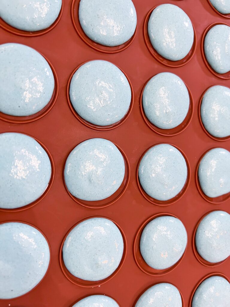 Light blue macarons on silicone mat