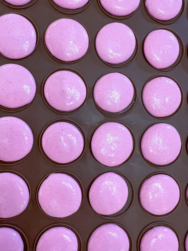 Pink macarons on silicone mat