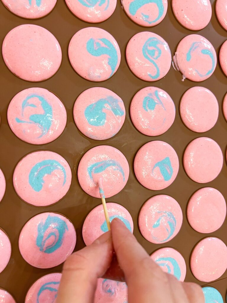 Using tooth stick to spread the macaron batter for multicolored shells