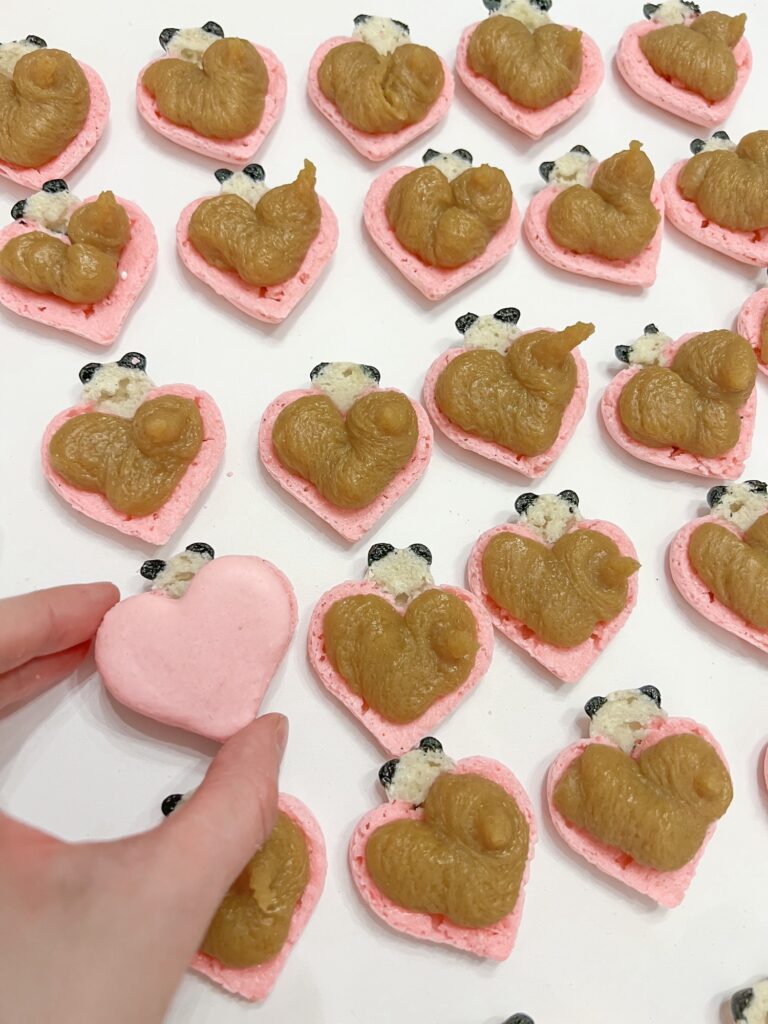 Filling cute heart shaped panda macarons with salted caramel