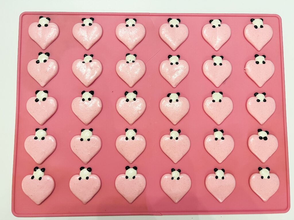 Heart-shaped macarons with panda faces on top
