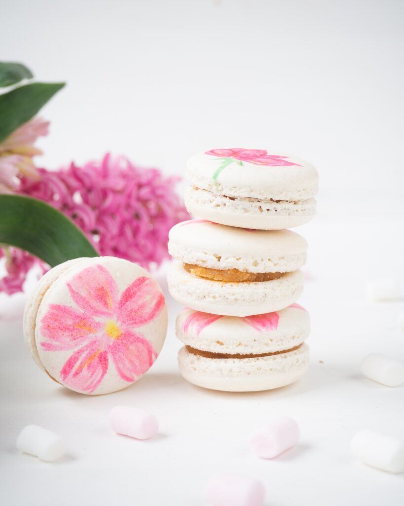 White macarons with flower painted on it